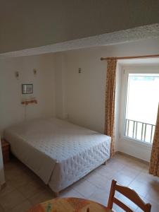 een slaapkamer met een wit bed en een raam bij Studio Appart Verdon in Allemagne-en-Provence