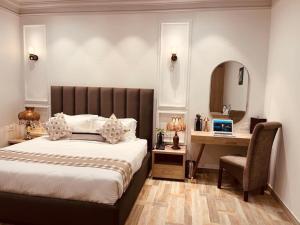 a bedroom with a bed and a desk and a mirror at Elegance Regency in Khanna