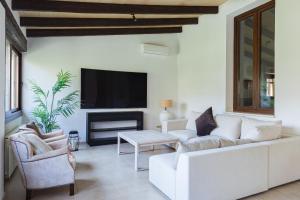 un soggiorno con divano bianco e TV di Villa Molinar a Palma de Mallorca