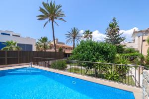 a swimming pool with a fence and palm trees at Villa Molinar in Palma de Mallorca