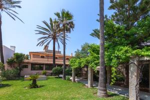 una casa con palmeras en el patio en Villa Molinar, en Palma de Mallorca