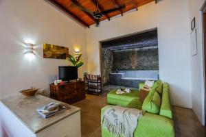 a living room with a green couch and a television at Margossa Residence Kandy - Two Bedroom Design Villa in Kandy