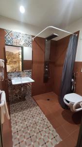 ein Bad mit einer Dusche, einem Waschbecken und einem WC in der Unterkunft BAGLIO TRAMONTANA in Gangi