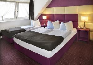 デュッセルドルフにあるホテル アム ヴィアハーンのホテルルーム ベッド2台&窓2つ付