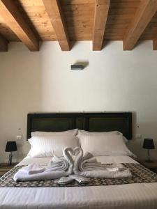 1 dormitorio con 1 cama con toallas en BAGLIO TRAMONTANA, en Gangi