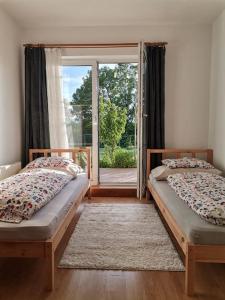 Duas camas num quarto com uma janela em Haus MARE - entspannen & sonnenbaden em Viskovo