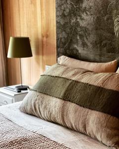 a bed with a pillow and a lamp on a table at VillaCanau in Lacanau