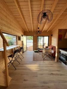 a living room with a wooden ceiling and a dining room at Wood11 - Charming TinyHouse in a Lovely Garden in Santa Bárbara de Nexe