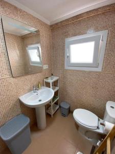 a bathroom with a sink and a toilet and a mirror at Casa Raquelina in Gijón