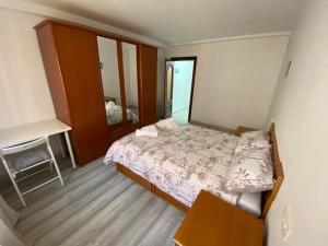 a bedroom with a bed and a desk and a mirror at Casa Raquelina in Gijón