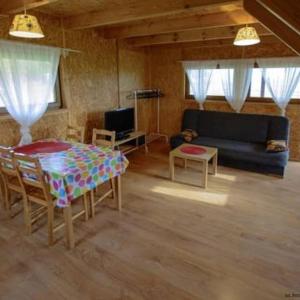 ein Wohnzimmer mit einem Tisch und einem Sofa in der Unterkunft Chatki Szymonówko in Maldeuten