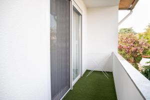 a small balcony with a green floor and a window at Apartment Adam in Zadar