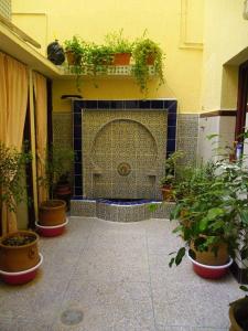 a courtyard with potted plants and a fireplace at ESCAPADE Assilah in Asilah