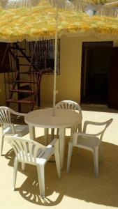 einen Tisch und Stühle mit einem Tisch und einem Sonnenschirm in der Unterkunft ESCAPADE Assilah in Asilah