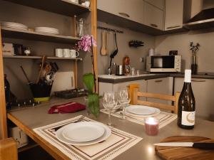 kuchnia ze stołem z talerzami i butelką wina w obiekcie Furnished & independant flat - Brides-les-bains - Thermal spa 50m w mieście Brides-les-Bains