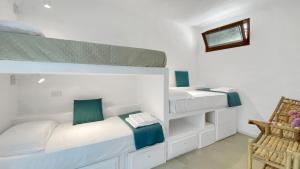 a bedroom with two bunk beds and a chair at La Maranita Apartment in La Maddalena
