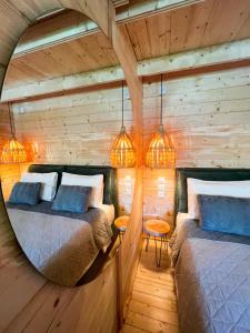 two beds in a room with wooden walls and lights at Elleria's House in Lefkada Town