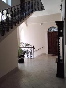 a hallway with a staircase and a wooden door at Garibaldi Guest House in LʼAquila
