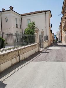 an empty street with two houses and a fence at Garibaldi Guest House in LʼAquila