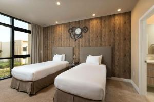 two beds in a hotel room with a clock on the wall at Private Hot Tub BBQ Grill at Magic Village Views in Orlando