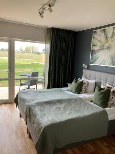 a bedroom with a large bed and a large window at Bedinge Golfklubb hotell in Beddinge Strand