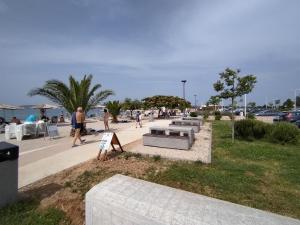 a park with benches and people walking on a sidewalk at Apartman Perkovic in Šibenik