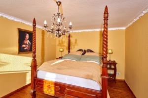 1 dormitorio con cama de madera y lámpara de araña en Ritterstube - Eifelstuben mit Charme, Nähe See und Burg, außergewöhnlich, Vulkaneifel, en Ulmen