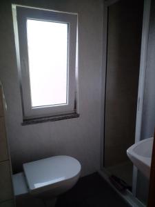 a bathroom with a white toilet and a window at FEWO Isla 1 in Elmenhorst