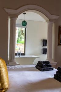 a room with a bed with columns and a window at Plaisir Estate Accommodation in Simondium