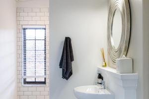 La salle de bains est pourvue d'un lavabo et d'un miroir. dans l'établissement Plaisir Estate Accommodation, à Simondium