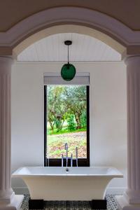 a bath tub in a room with a window at Plaisir Estate Accommodation in Simondium