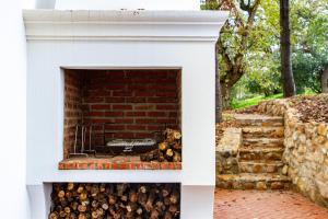 a white fireplace with a pile of logs at Plaisir Estate Accommodation in Simondium