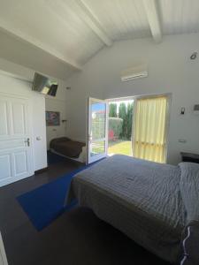 ピストイアにあるPodere Villa Olmoのベッドルーム1室(ベッド1台付)、スライド式ガラスドアが備わります。