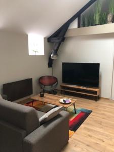 a living room with a couch and a flat screen tv at Escale à Fécamp 4 étoiles - garage privé in Fécamp