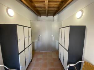 a locker room with white and black lockers at Casa Amada con piscina in Murias de Pedredo