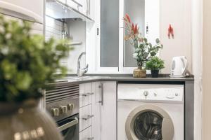 a kitchen with a washing machine and a sink at Suite Place Barcelona Diputació in Barcelona