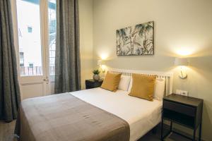 Un dormitorio con una cama grande y una ventana en Suite Place Barcelona Diputació, en Barcelona