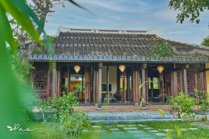 uma casa com um telhado de madeira e um jardim em Pao Homes - An Hai Villa, Family-Friendly Villa with Pool em Hoi An