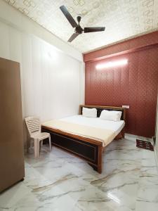 a bedroom with a bed and a ceiling fan at Saraswati Palace in Varanasi
