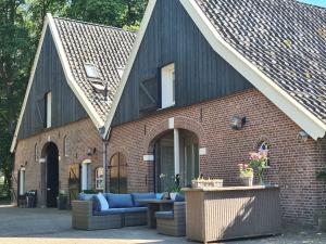 Weleveld的住宿－蘭德格依得拉威酒店，一座砖砌建筑,在庭院里设有蓝色的沙发