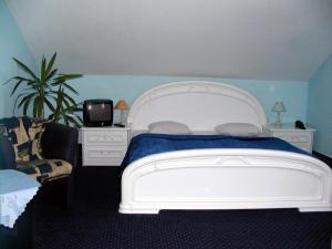 sypialnia z białym łóżkiem i telewizorem w obiekcie Zajazd Dajana w Ustce