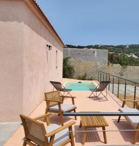 balcón con sillas y piscina en Gite Capparone 1, en Bastelicaccia
