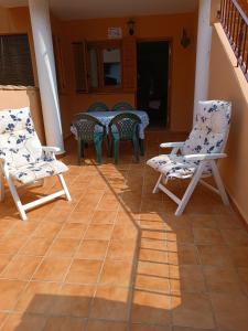 eine Terrasse mit Stühlen, einem Tisch und einem Tisch in der Unterkunft El Roalico in Los Alcázares