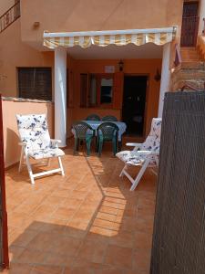 eine Terrasse mit Stühlen und Tischen auf einem Haus in der Unterkunft El Roalico in Los Alcázares