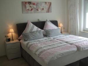 a bedroom with a bed with pillows and two lamps at Ferienwohnung Hankeln in Winterberg