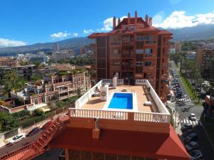 プエルト・デ・ラ・クルスにあるApartamento Paraiso Valle Luzの屋上スイミングプール付きの建物の景色を望めます。