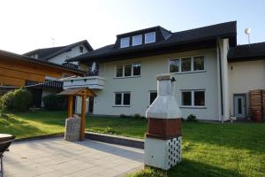 a large white house with a large bottle in the yard at Ferienwohnung Hankeln in Winterberg