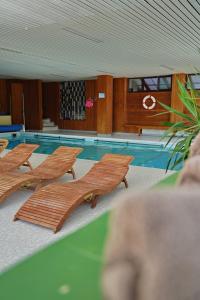 a swimming pool with wooden loungers in front of a swimming pool at Villa Bello in Berchtesgaden