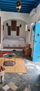 Habitación con cama y mesa. en Dar Michèle Djerba en Houmt El Souk