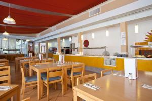 um restaurante com mesas e cadeiras de madeira e um balcão em Seth Mestral & Llebeig em Santo Tomás